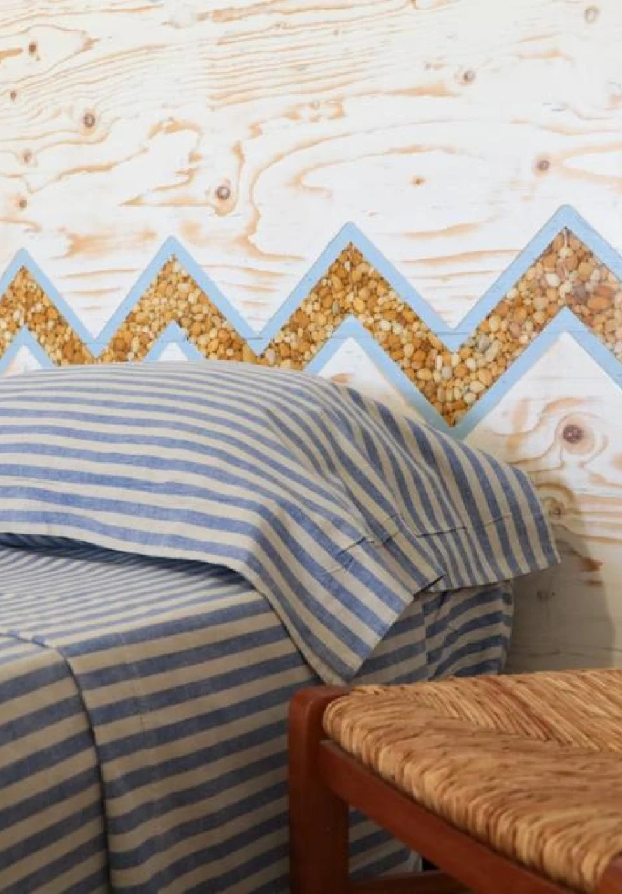 Camera da letto con testiera in legno dipinto e plaid a righe