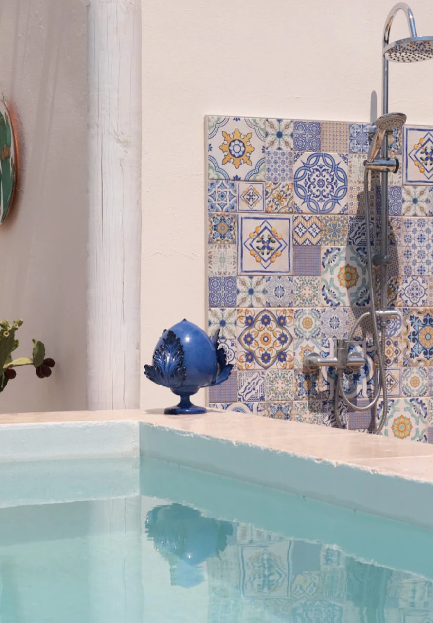 Piscina con parete rivestita in ceramica salentina