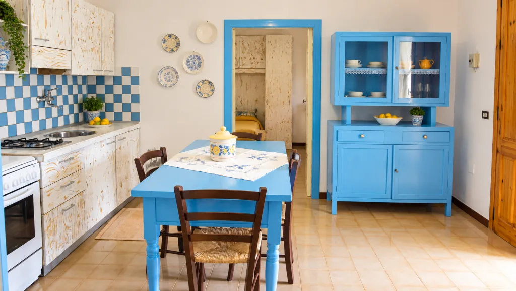 Cucina in stile mediterraneo con tavolo blu e madia