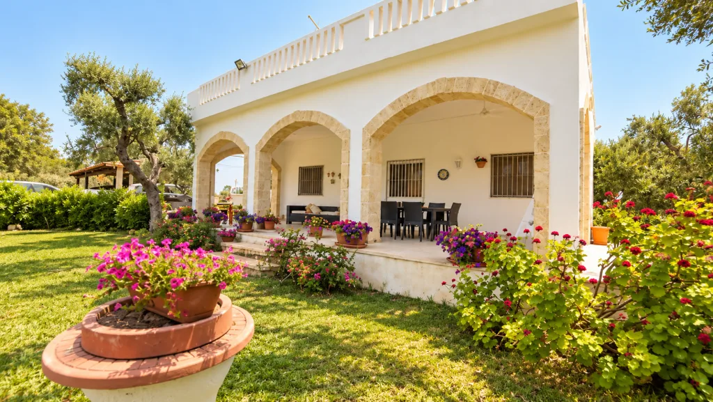 Facciata della casa di giorno con tavolo da pranzo e barbecue in giardino