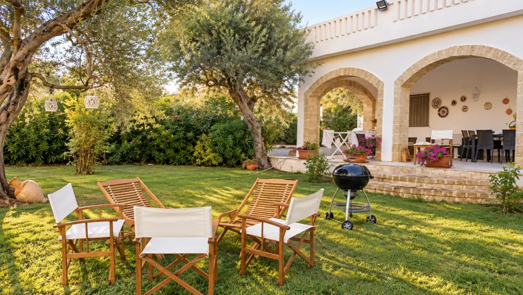 Angolo relax in giardino con poltrone e barbecue