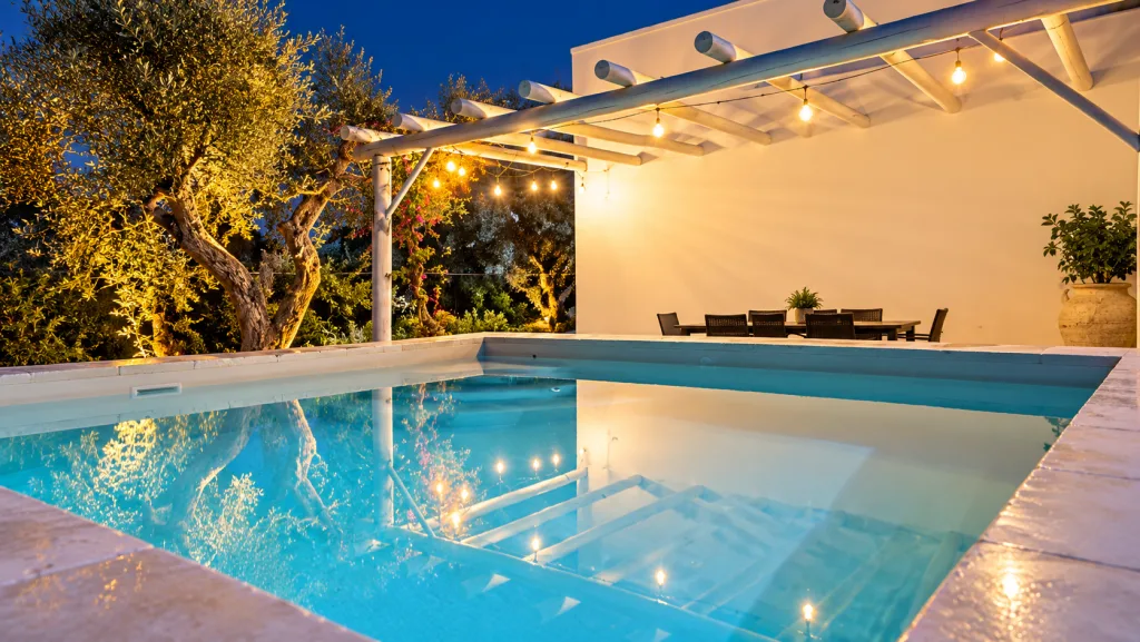Piscina con pergola illuminata al tramonto