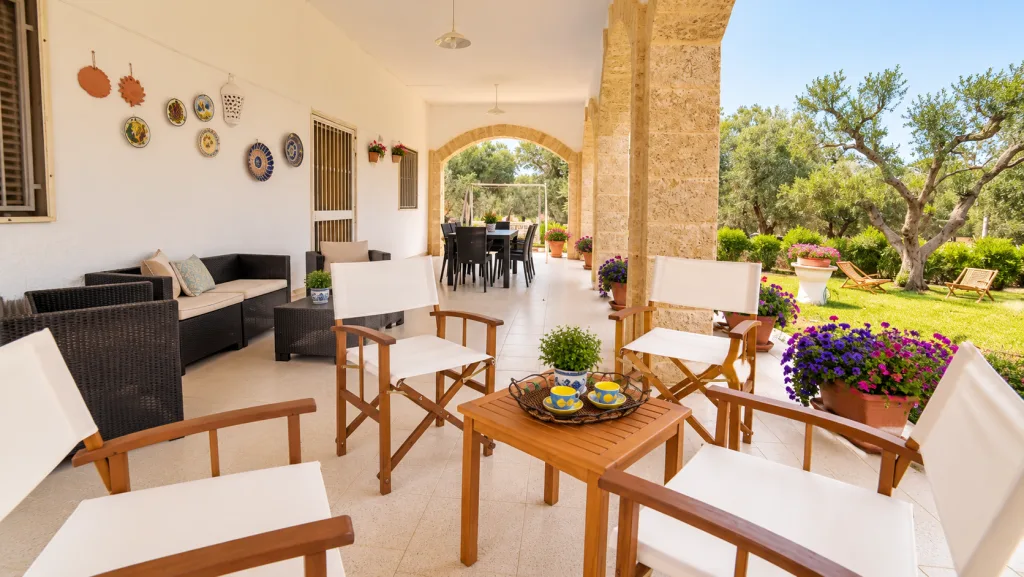 Veduta del portico con salotto in vimini e ceramiche appese alla parete