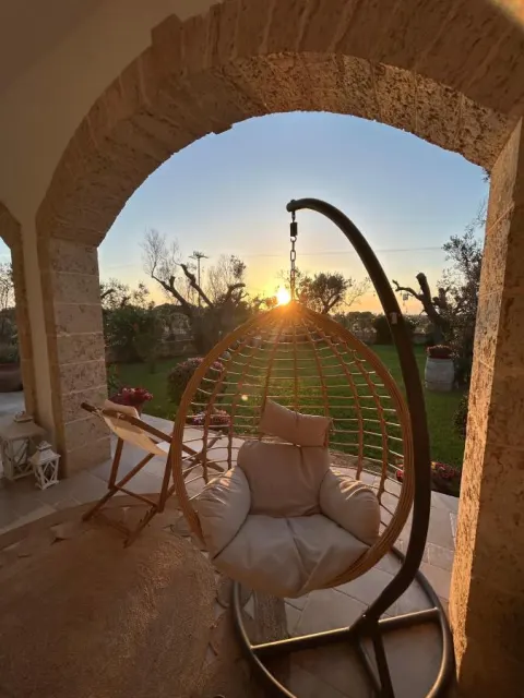 Dondolo in vimini sul portico al tramonto