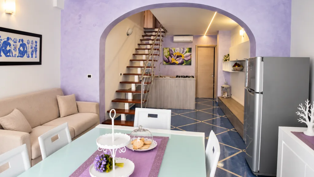 Sala da pranzo con vista sulla cucina e la scala