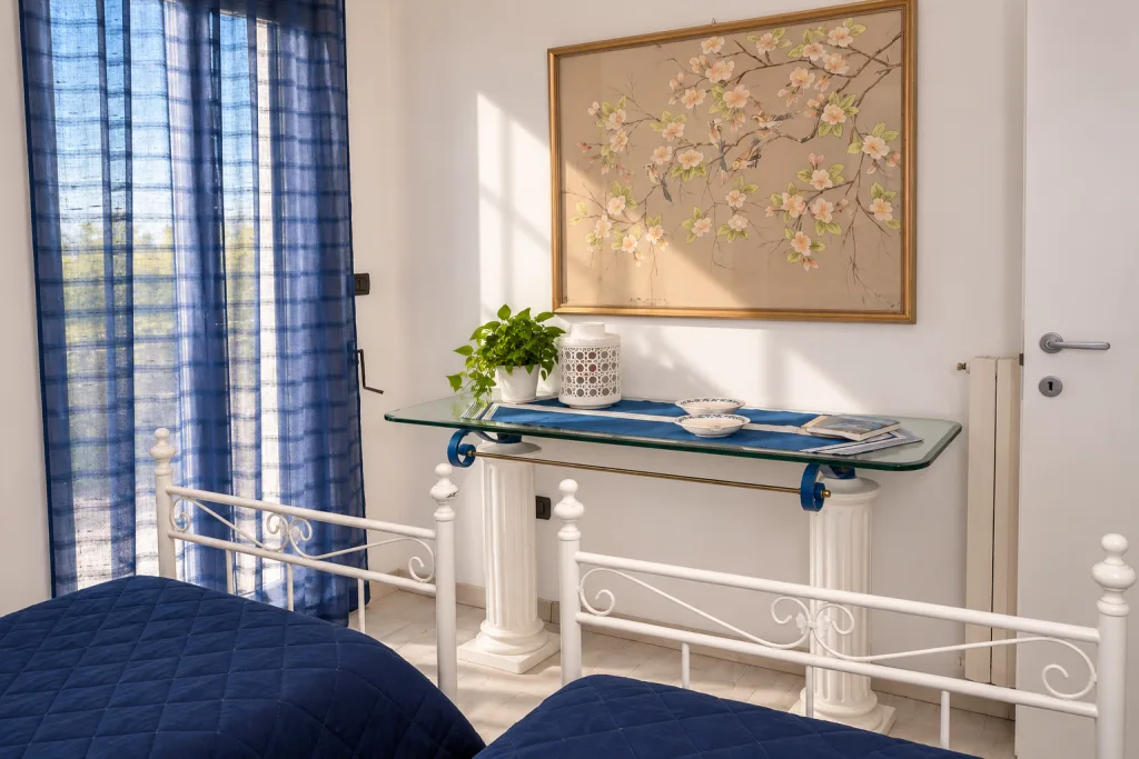 Consolle con quadro floreale tra i due letti
