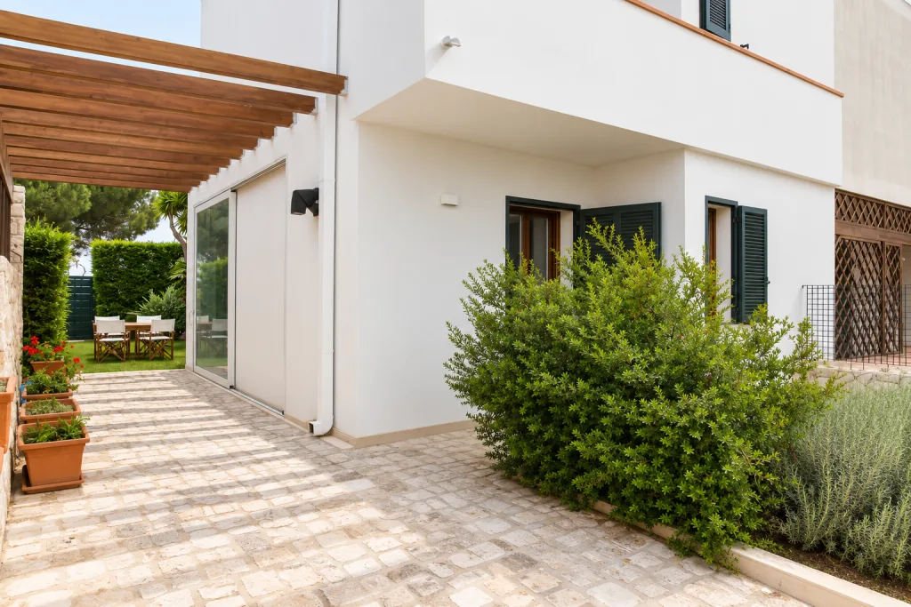 Vialetto del giardino con set da pranzo sotto la pergola
