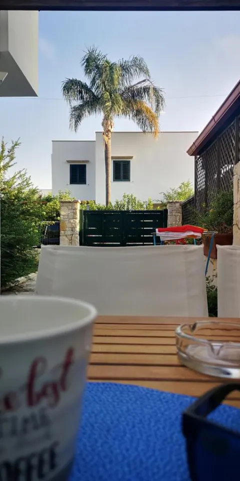 Caffè sul tavolo della veranda con vista sul giardino e la villa